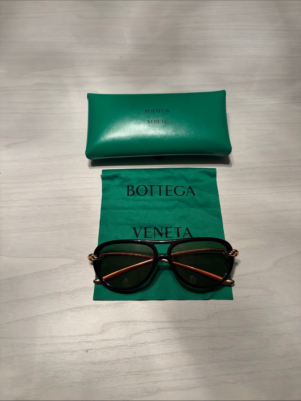 Bottega Veneta Black Frame Sunglasses with Gold-Tone Accents and Green Case